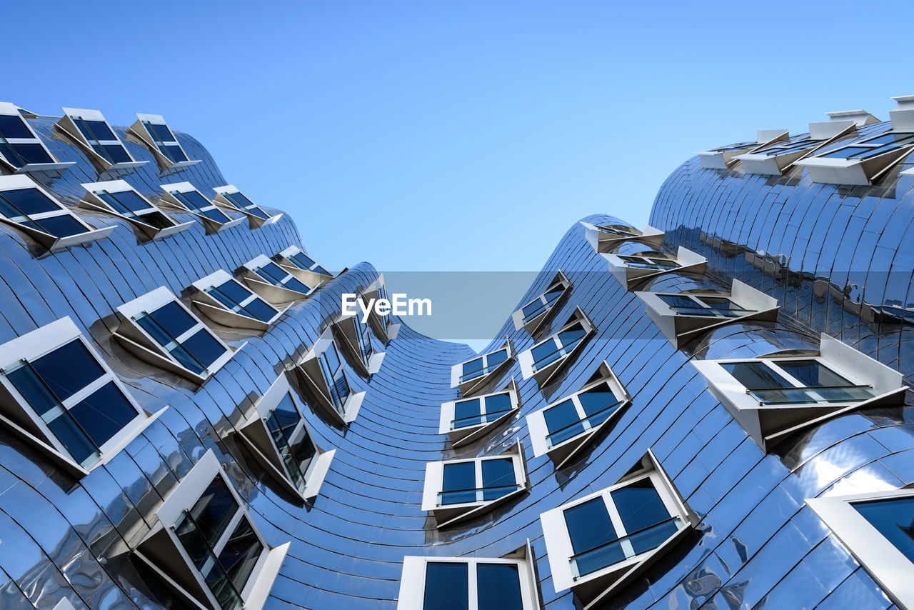 LOW ANGLE VIEW OF BUILDINGS AGAINST BLUE SKY