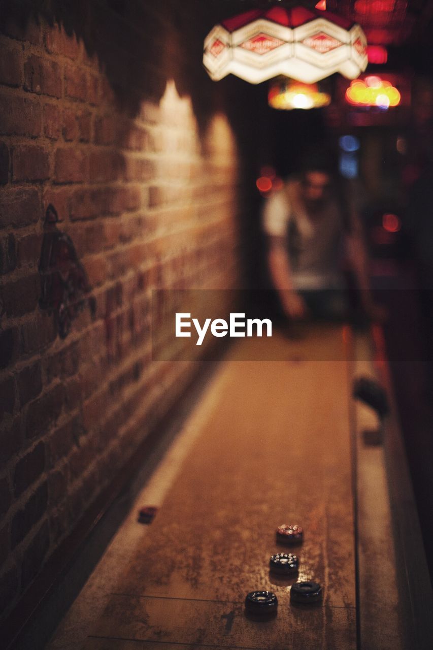 Man playing game by brick wall in bar