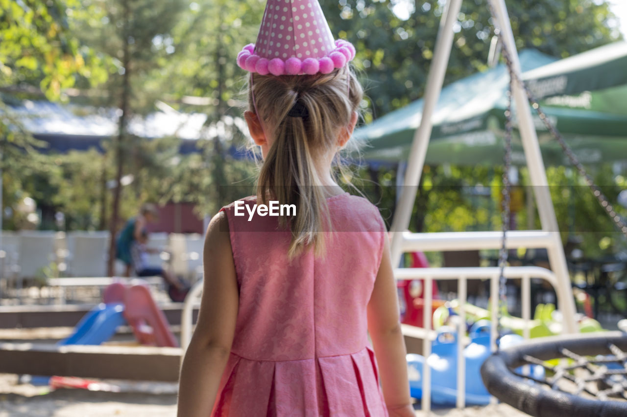 Rear view of girl standing at playground