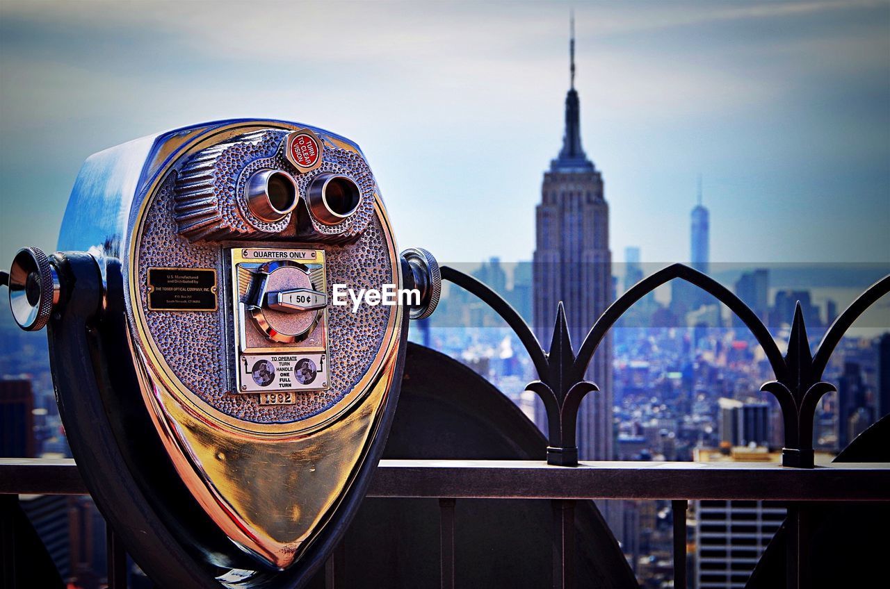 Coin-operated binoculars at railing against empire state building
