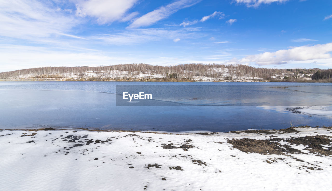 FROZEN LAKE AGAINST SKY