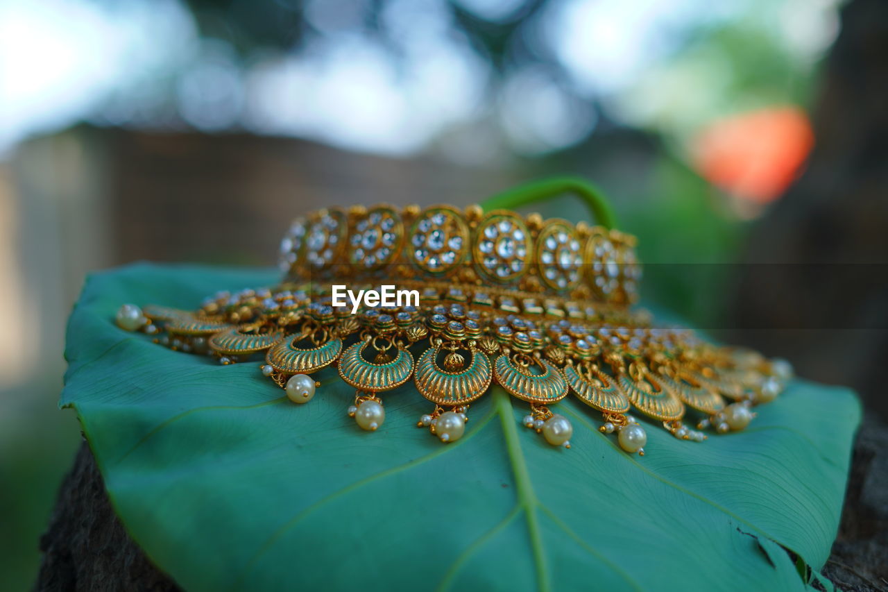 green, macro photography, fashion accessory, flower, jewellery, yellow, close-up, jewelry, focus on foreground, no people, leaf, gold, nature, selective focus, outdoors, pattern, wedding, plant, day