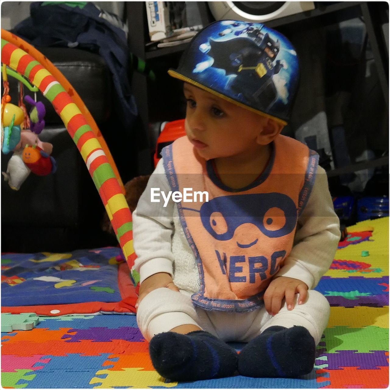 FULL LENGTH OF BOY SITTING IN MULTI COLORED KITCHEN