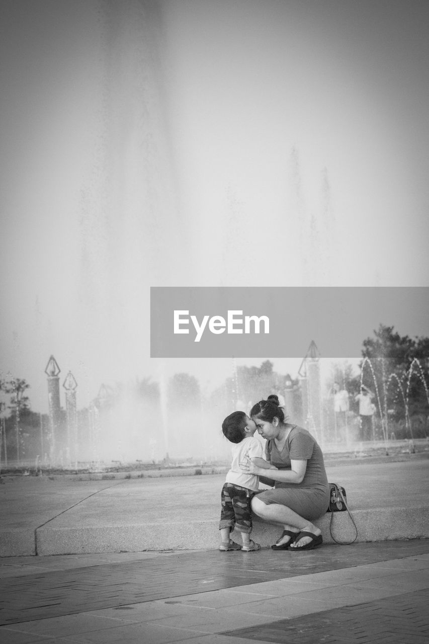 Mother with son against fountain