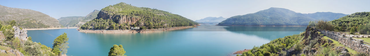 scenic view of lake by mountains against sky