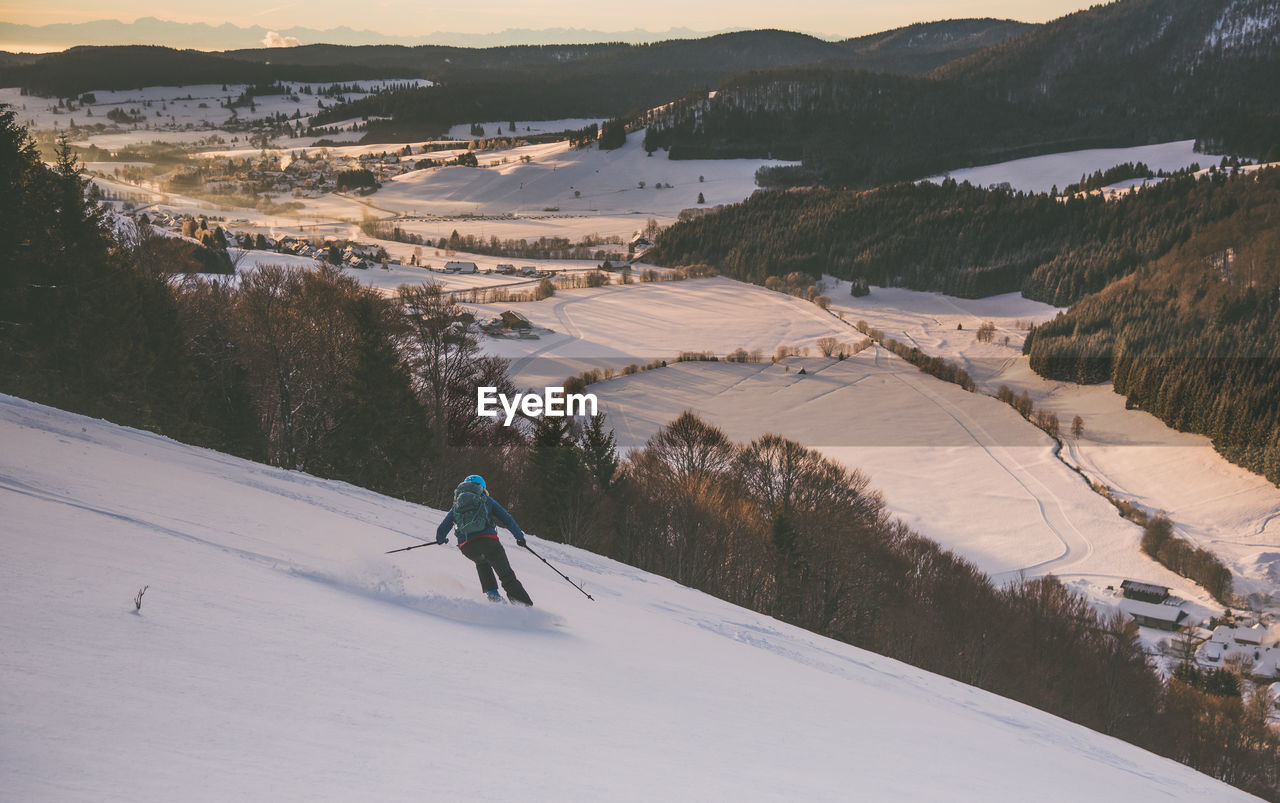 Rear view of person skiing on snowcapped mountain