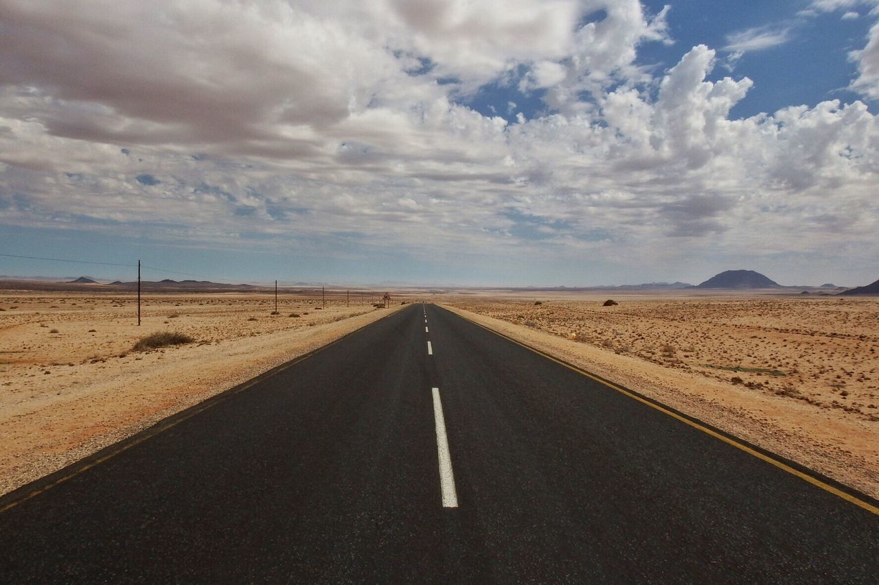 Empty road against cloudy sky