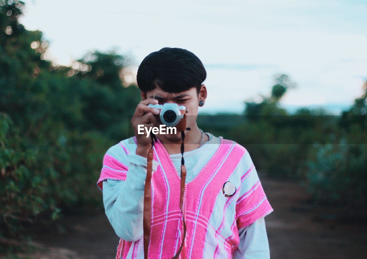 Young man photographing through camera