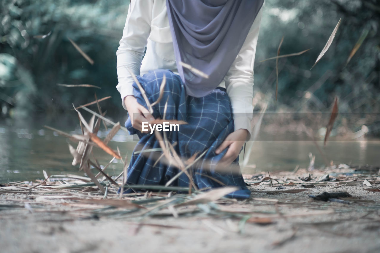 Midsection of woman amidst falling leaves