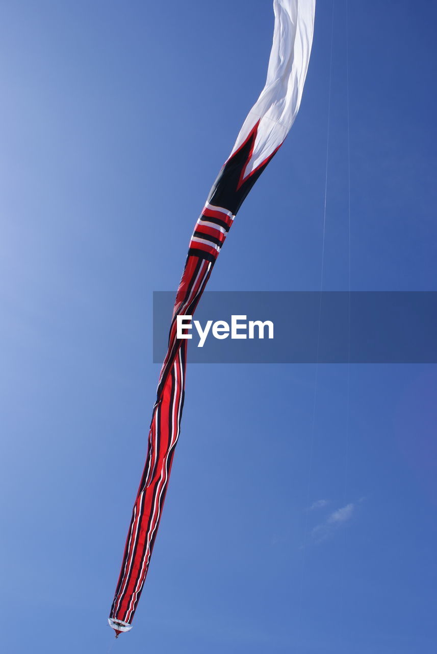 Traditional bali  kite with a very large size and long tail is flying on the sanur, bali, indonesia.