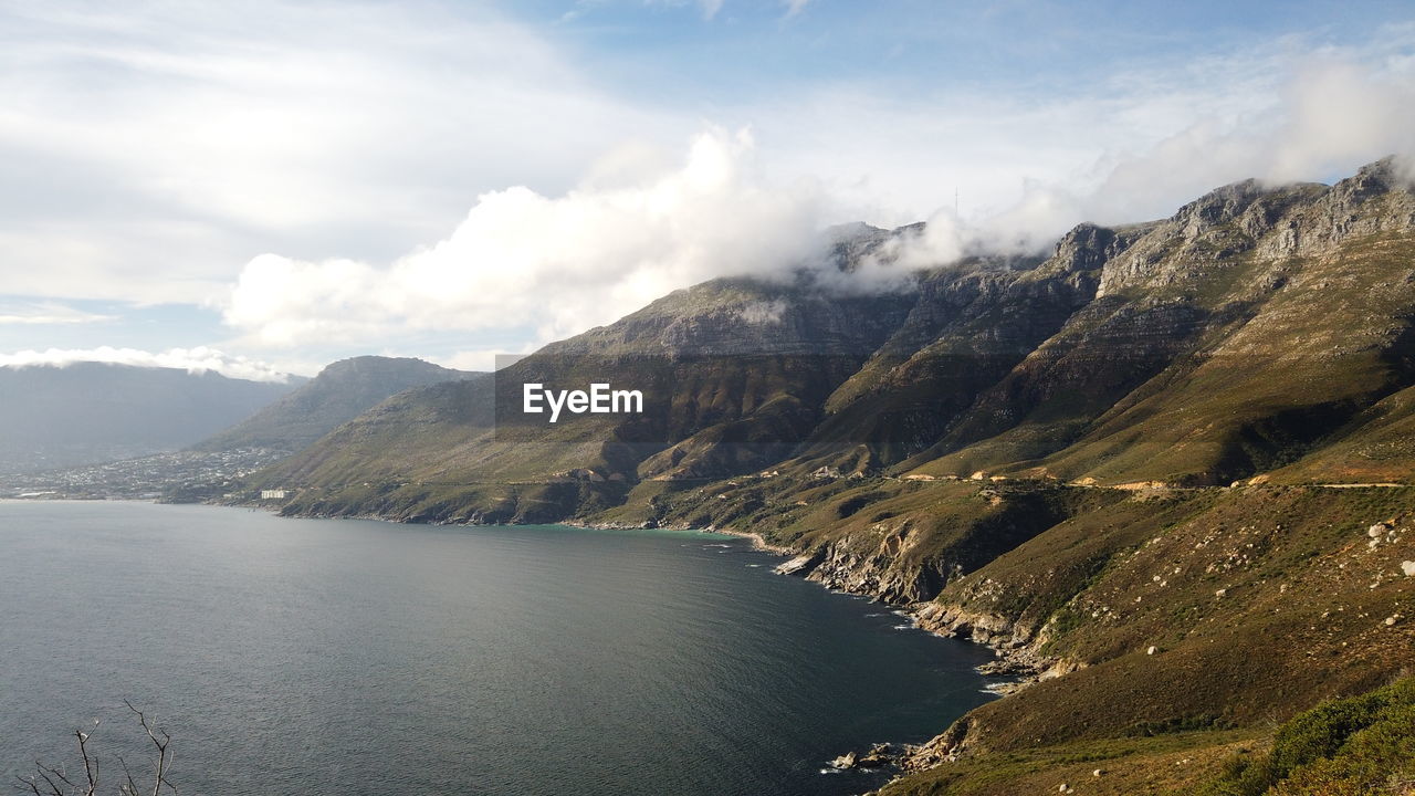 Scenic view of lake by mountains against sky