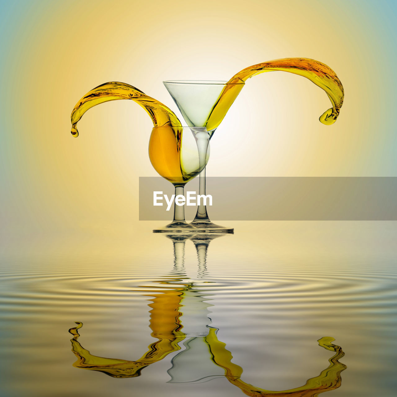 Close-up of water splash from glass in water at sunset