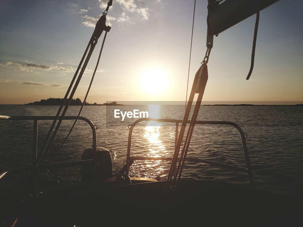 Cropped boat at calm sea against sunset