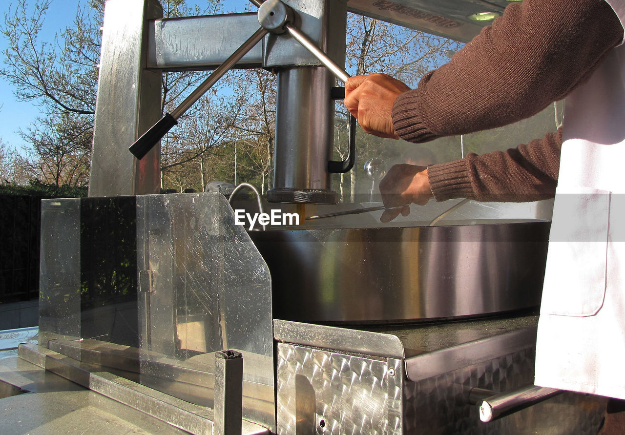 Cropped image of chef making churros in machine