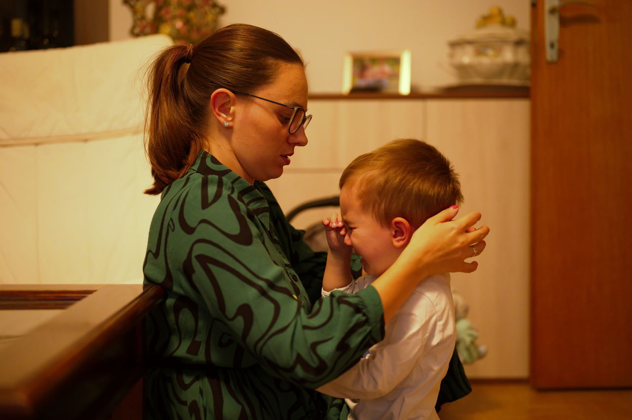 Mother comforting crying toddler at home