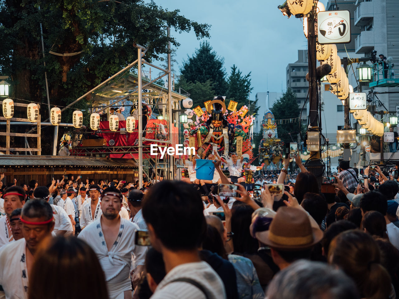 PEOPLE ON STREET IN CITY AGAINST TREES