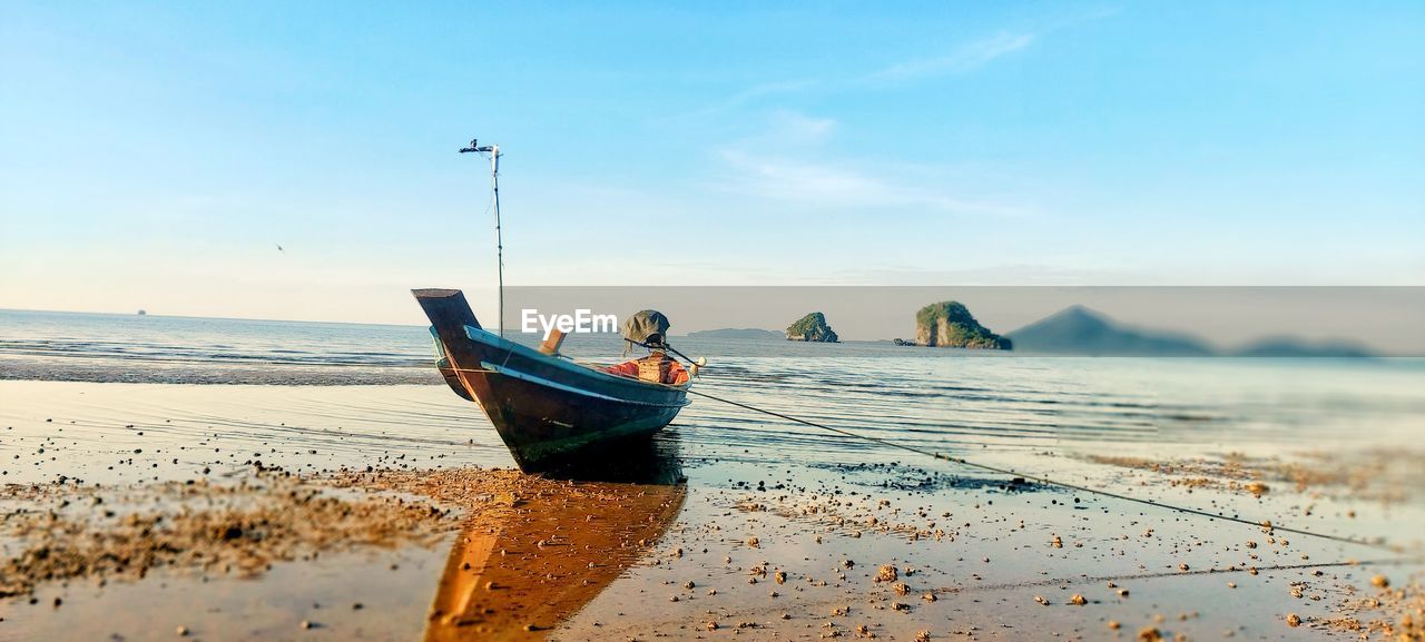 boat moored on beach against sky