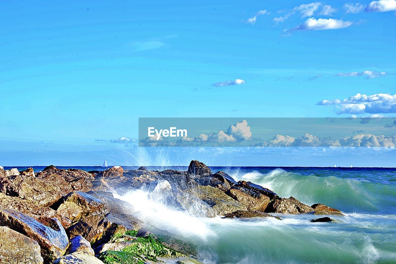 water, sea, shore, wave, ocean, sky, coast, beauty in nature, scenics - nature, nature, land, body of water, motion, beach, wind wave, rock, blue, cloud, no people, horizon over water, environment, day, water sports, outdoors, horizon, tranquil scene, travel destinations, sports, vacation, bay, tranquility, splashing, idyllic, long exposure, non-urban scene, landscape