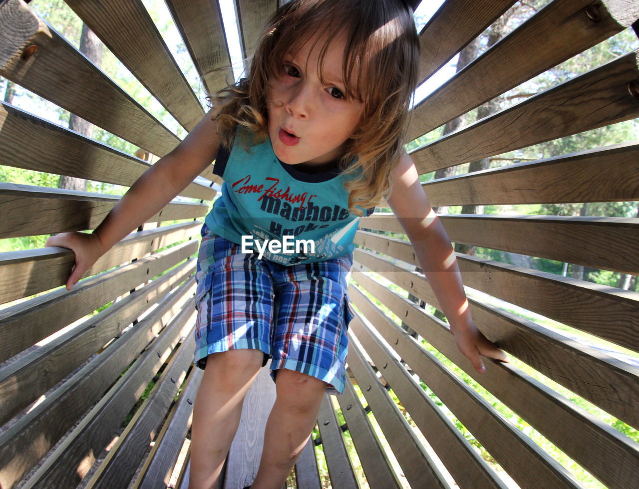 Portrait of cute boy against wooden structure