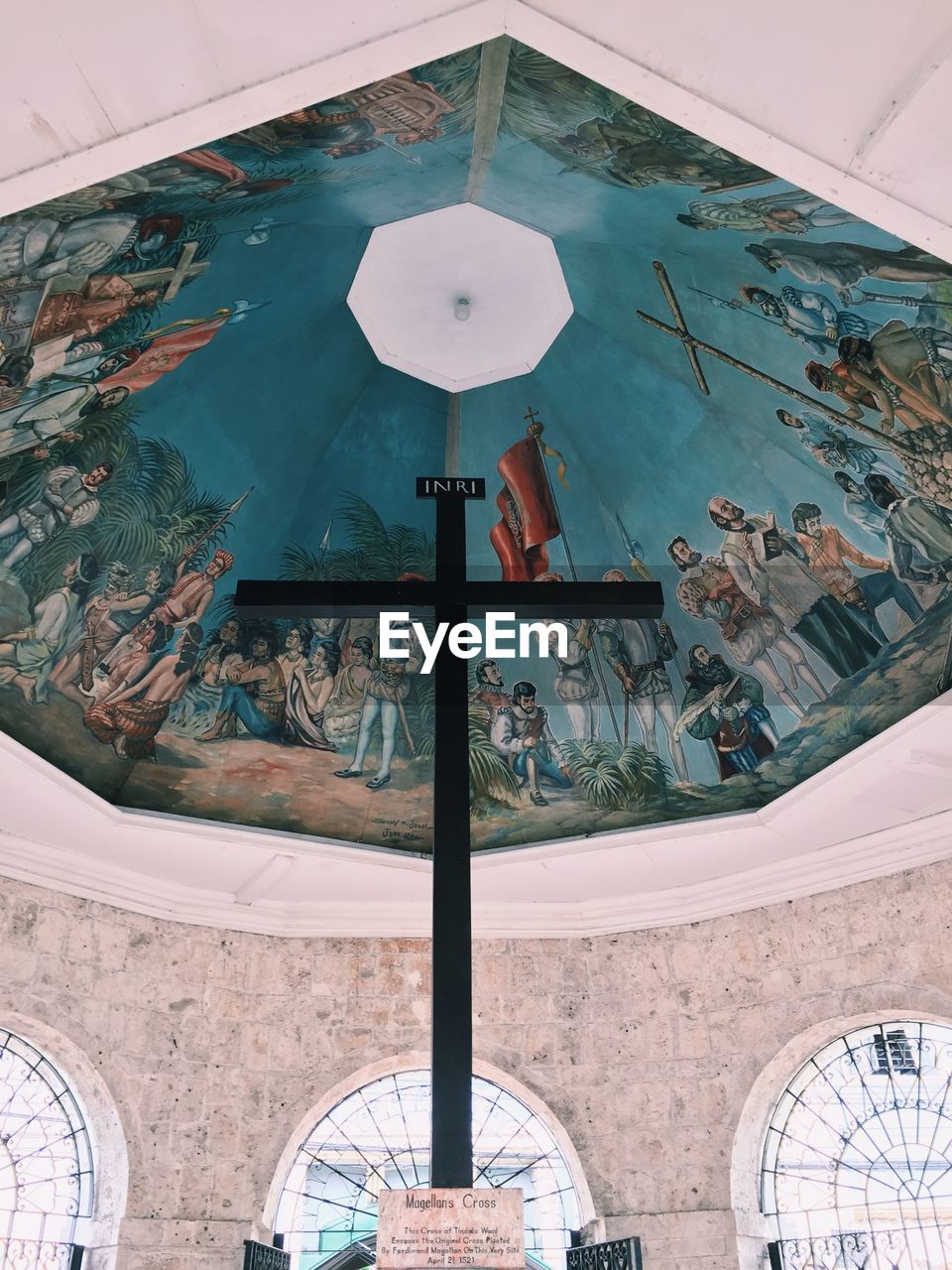 LOW ANGLE VIEW OF CLOCK ON BUILDING SEEN THROUGH WINDOW