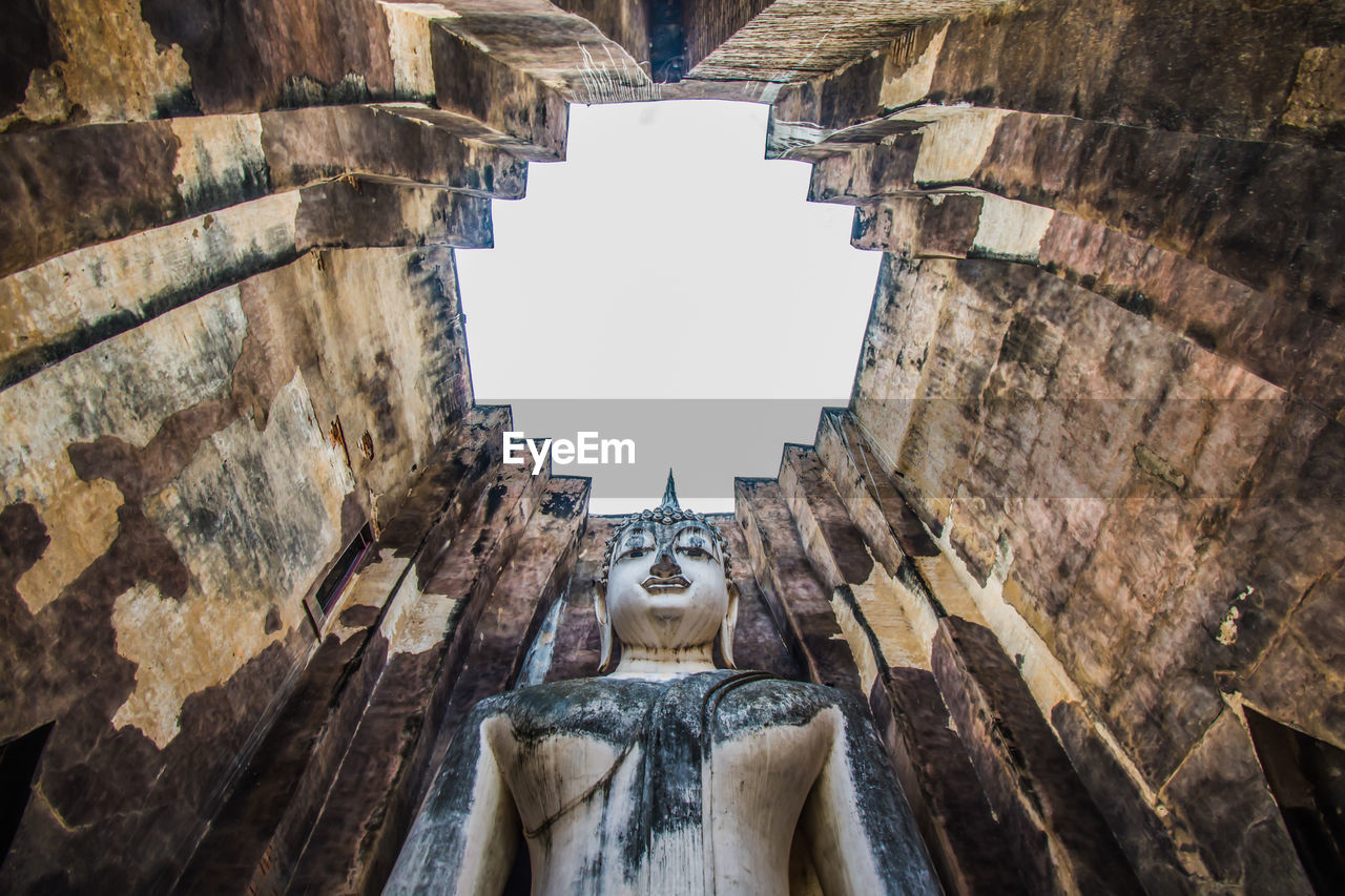 Low angle view of statue in temple against sky