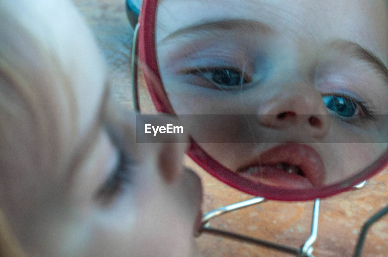 Close-up of cute baby girl looking into mirror