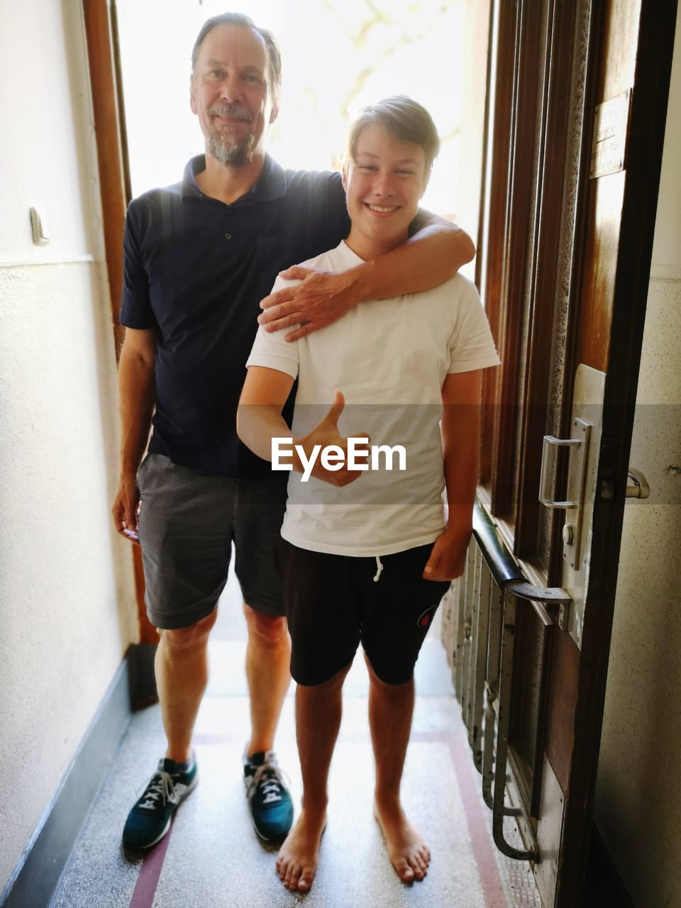 PORTRAIT OF HAPPY FRIENDS STANDING IN BUILDING