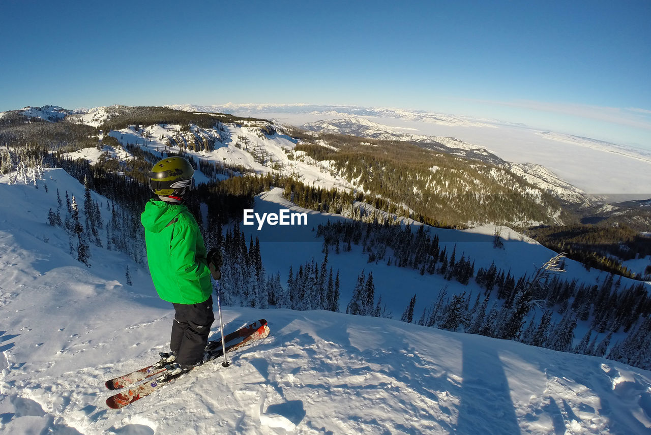 Full length of skier standing on snow covered field