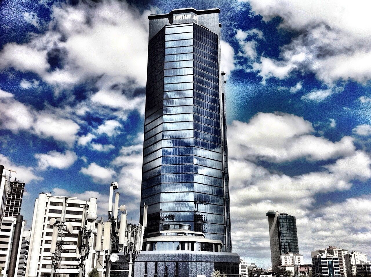 LOW ANGLE VIEW OF SKYSCRAPERS AGAINST CLOUDY SKY