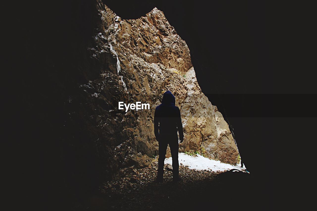 Rear view of man standing in cave