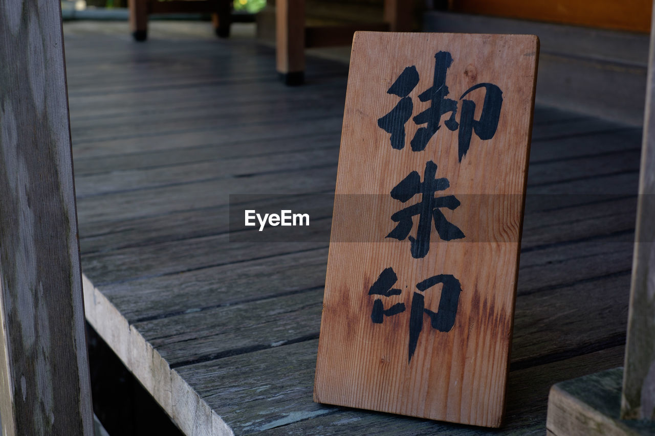 Close-up of non-western script on wooden plank in temple