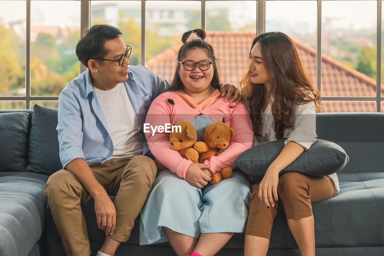 Asian family of father and mother with down syndrome teenager daughter having fun together