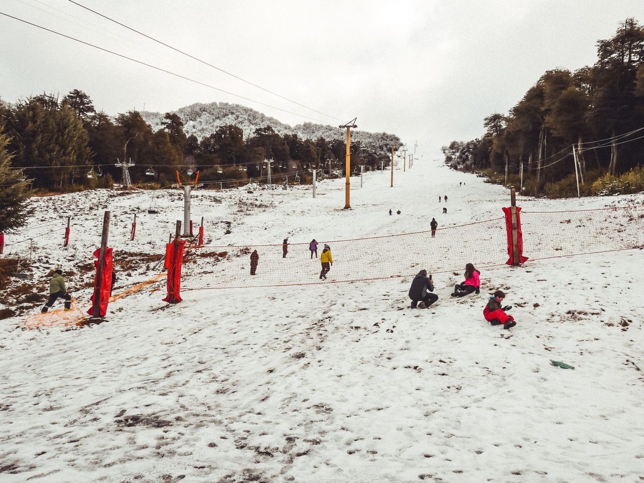 People on snow covered field against sky