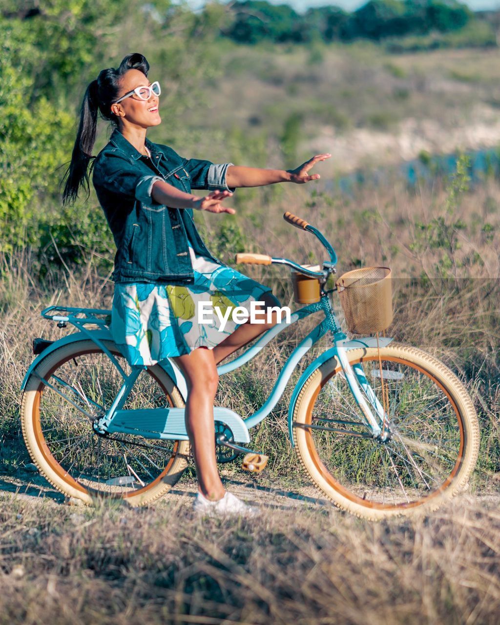 Full length of woman riding bicycle on road