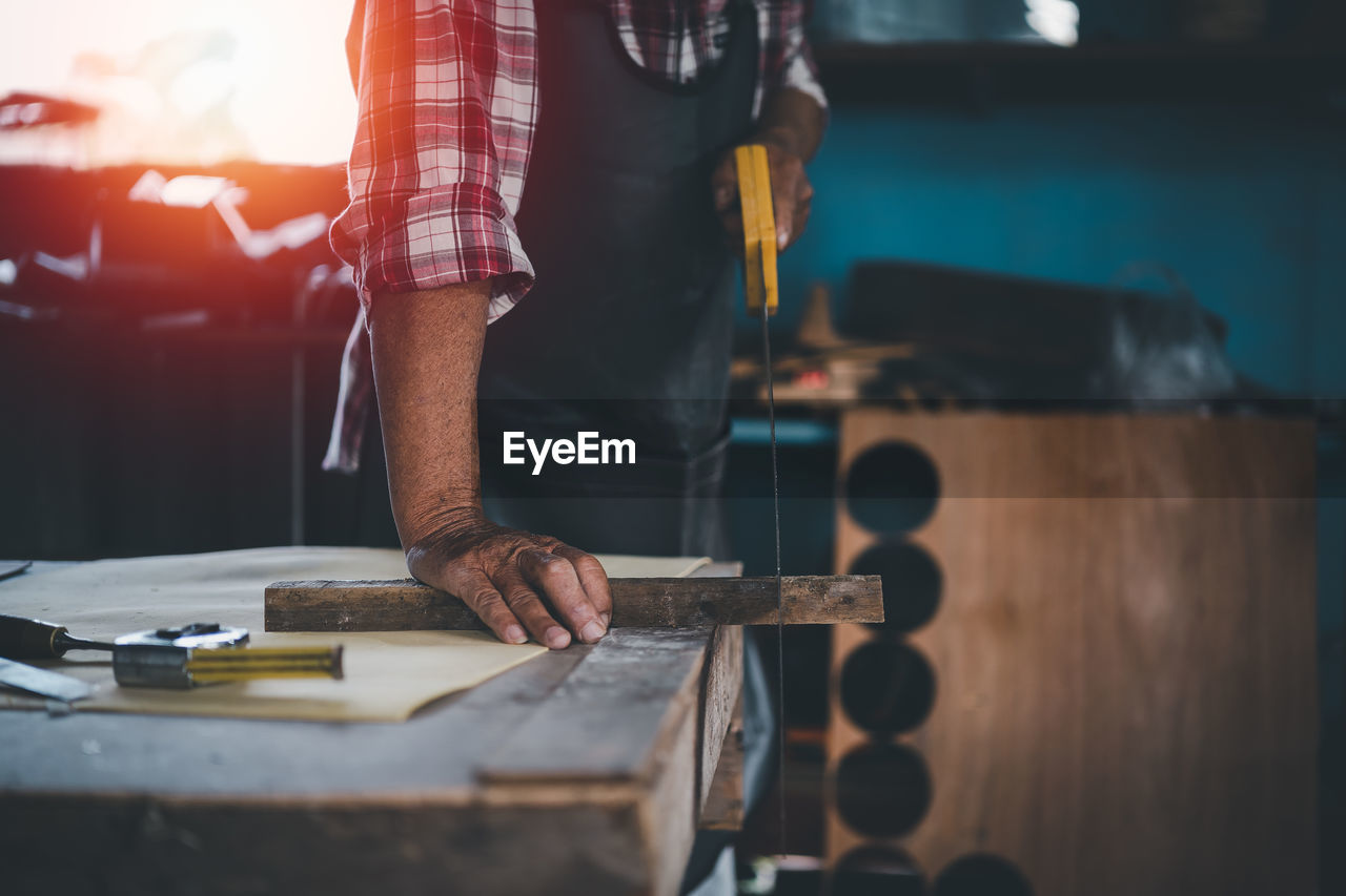 Cropped hand of man working at workshop