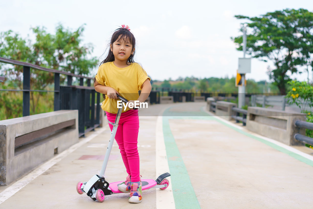 Portrait of young woman exercising on road