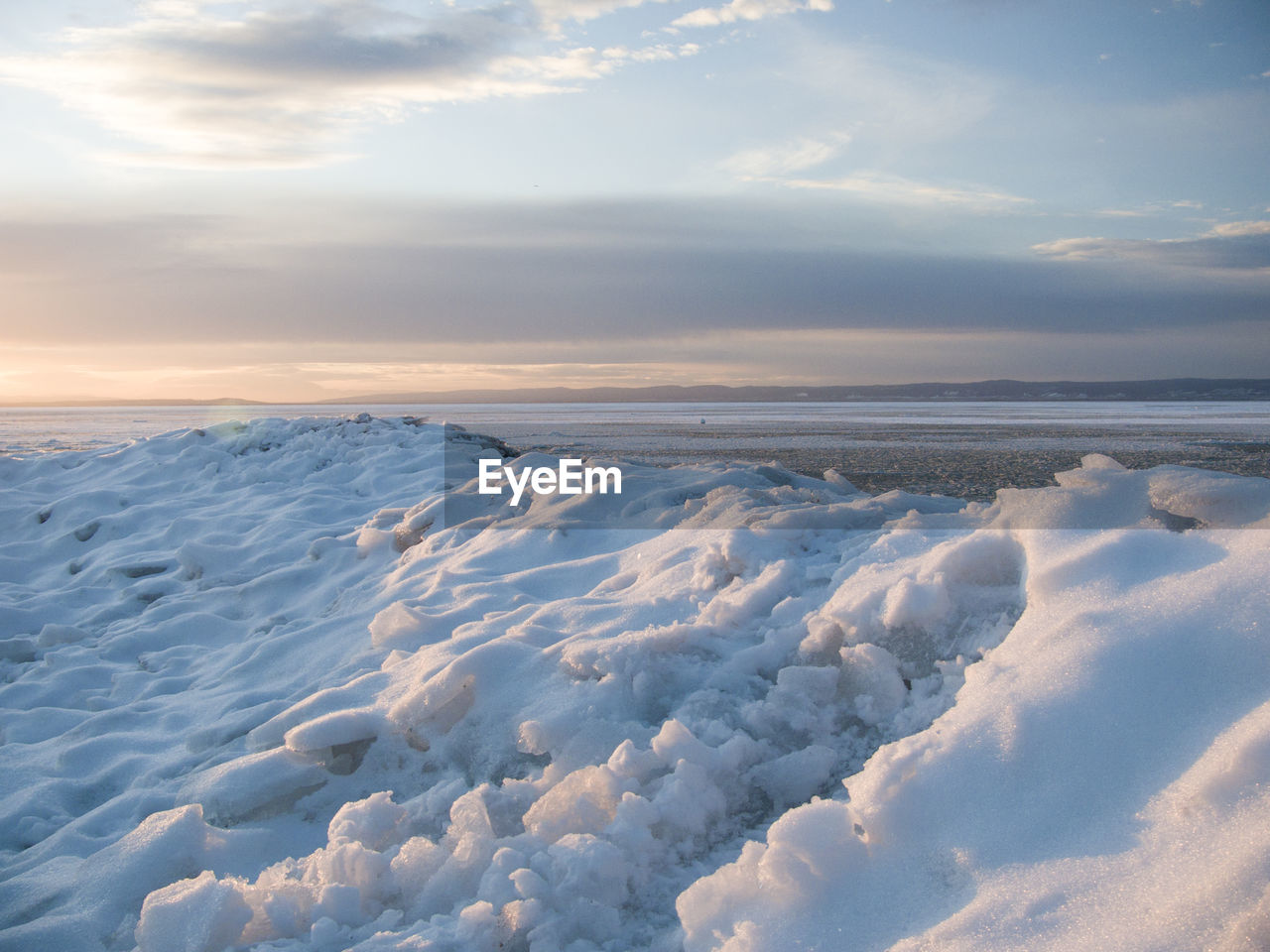 Scenic view of frozen lake neusiedl against sky during sunset