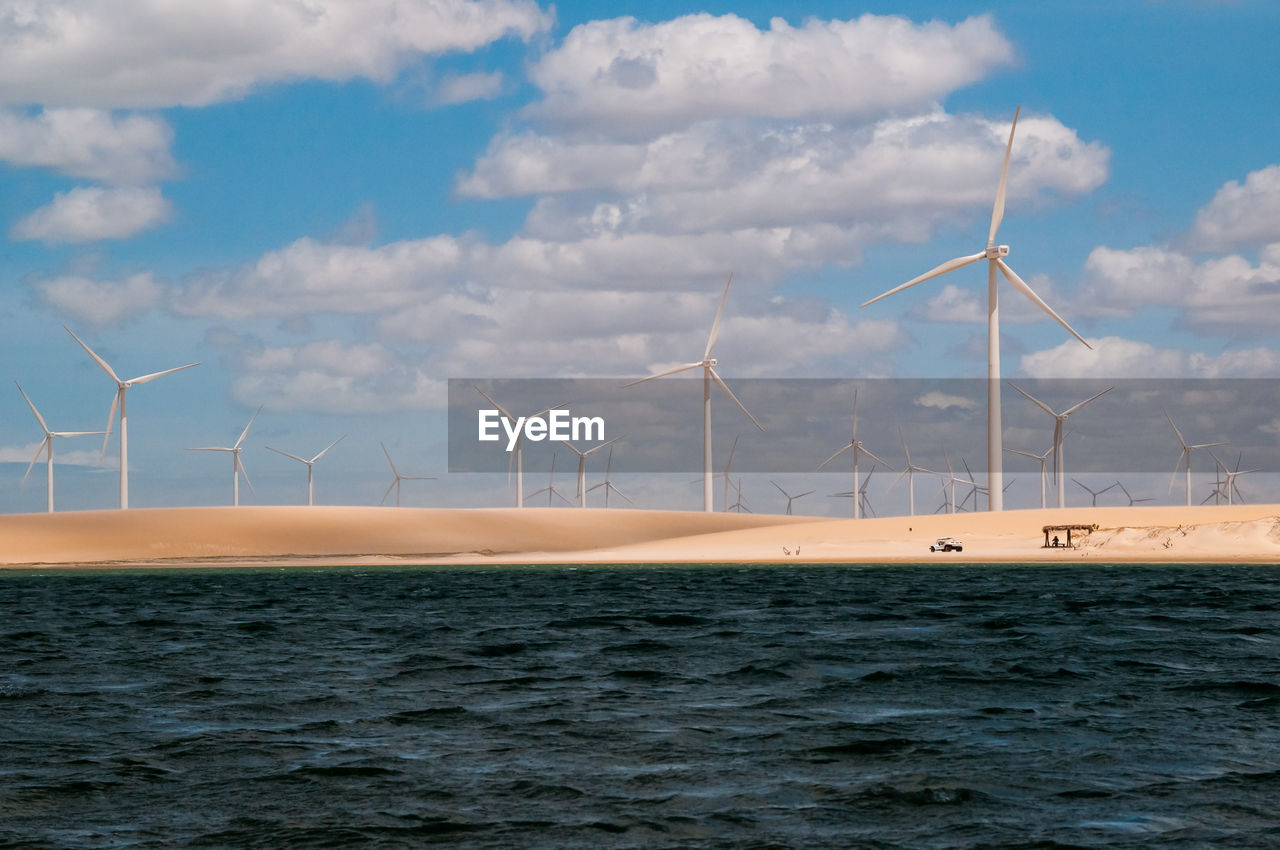 WINDMILLS ON SEA AGAINST SKY