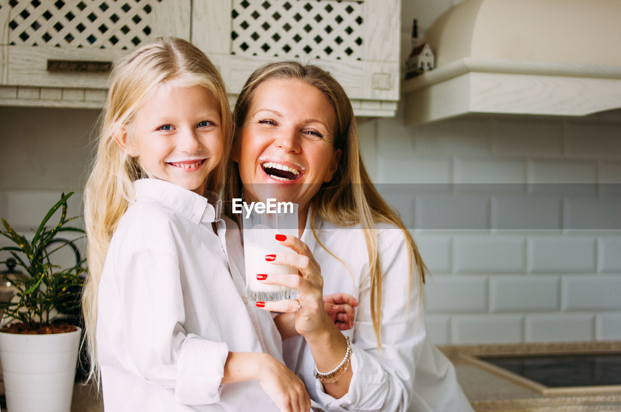 Portrait of happy mother and daughter in kitchen at home