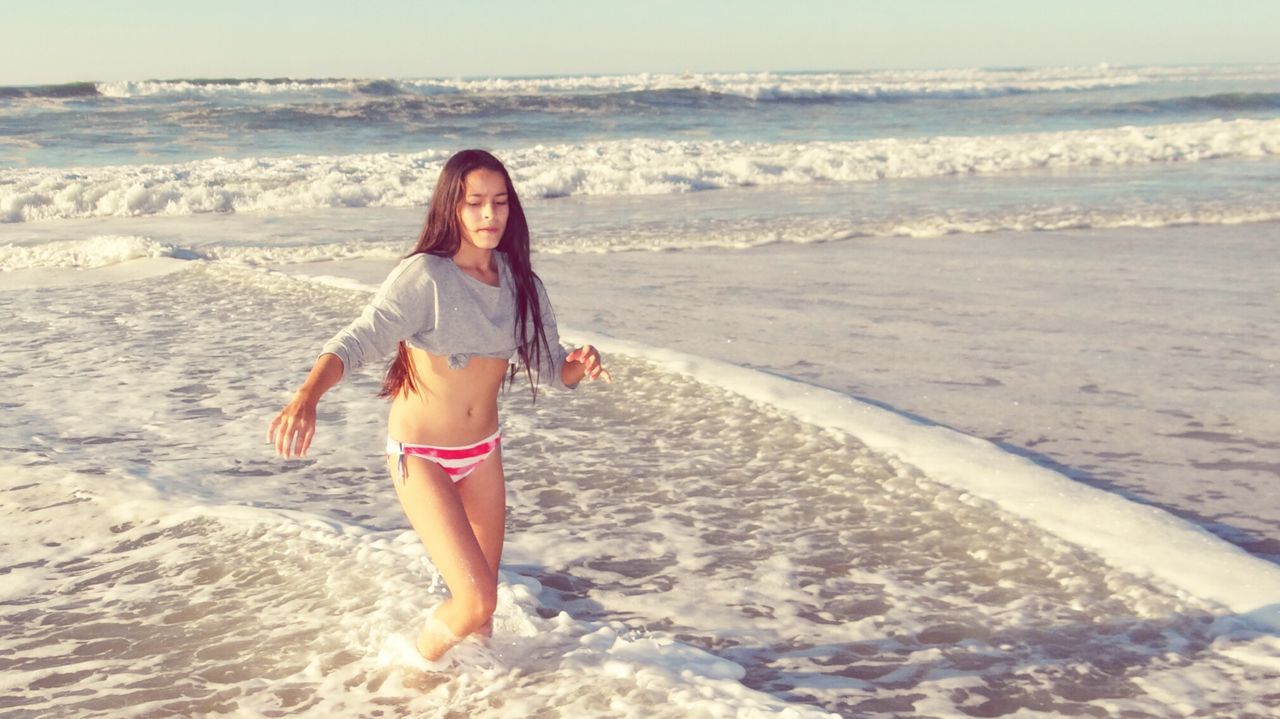Teenage girl walking at beach