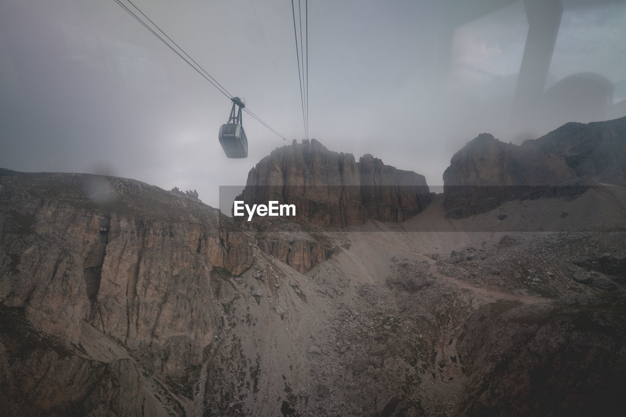 VIEW OF OVERHEAD CABLE CAR AGAINST SKY