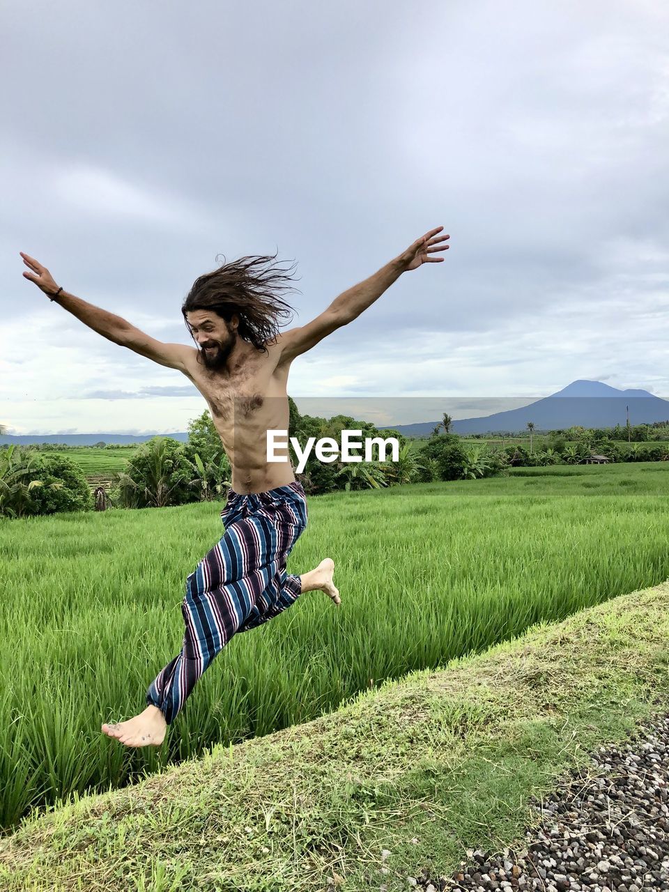 FULL LENGTH OF BOY JUMPING ON FIELD