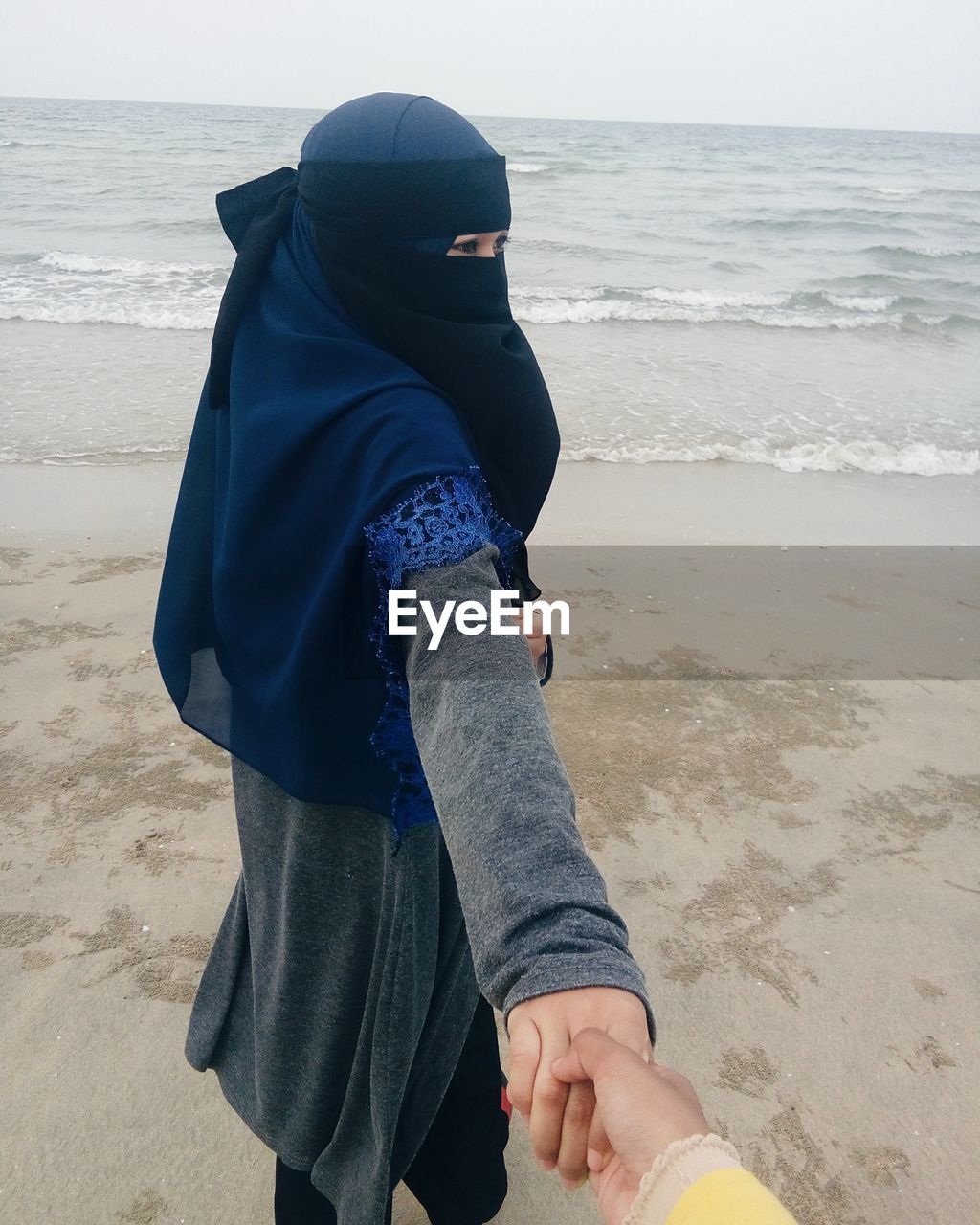 WOMAN STANDING ON BEACH