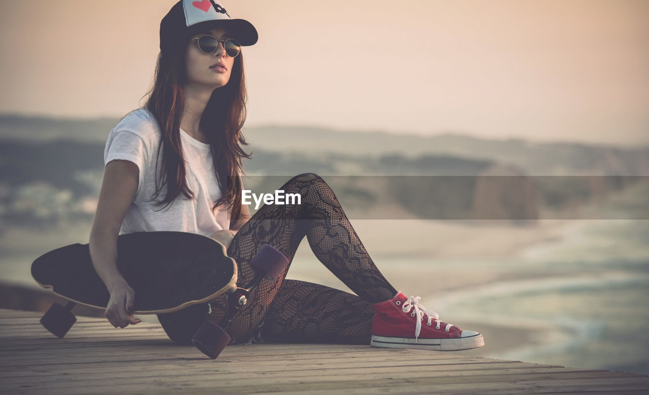 Beautiful young girl with her skateboard