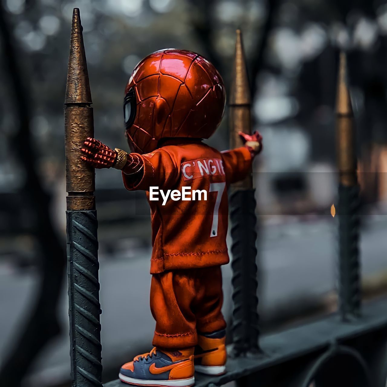 CLOSE-UP OF BOY WITH UMBRELLA STANDING ON METAL STRUCTURE