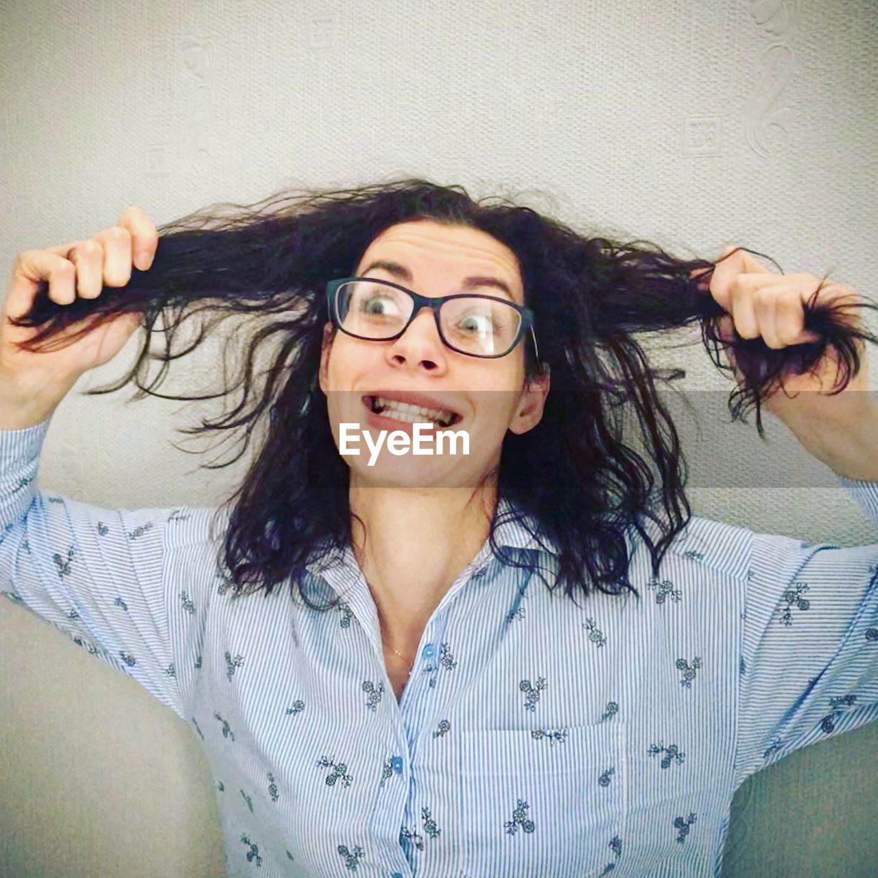 PORTRAIT OF A SMILING YOUNG WOMAN WEARING EYEGLASSES