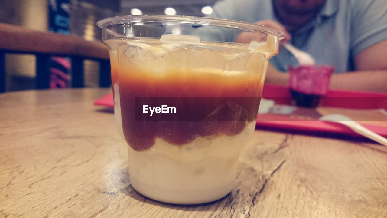 Close-up of desert served in disposable glass on table