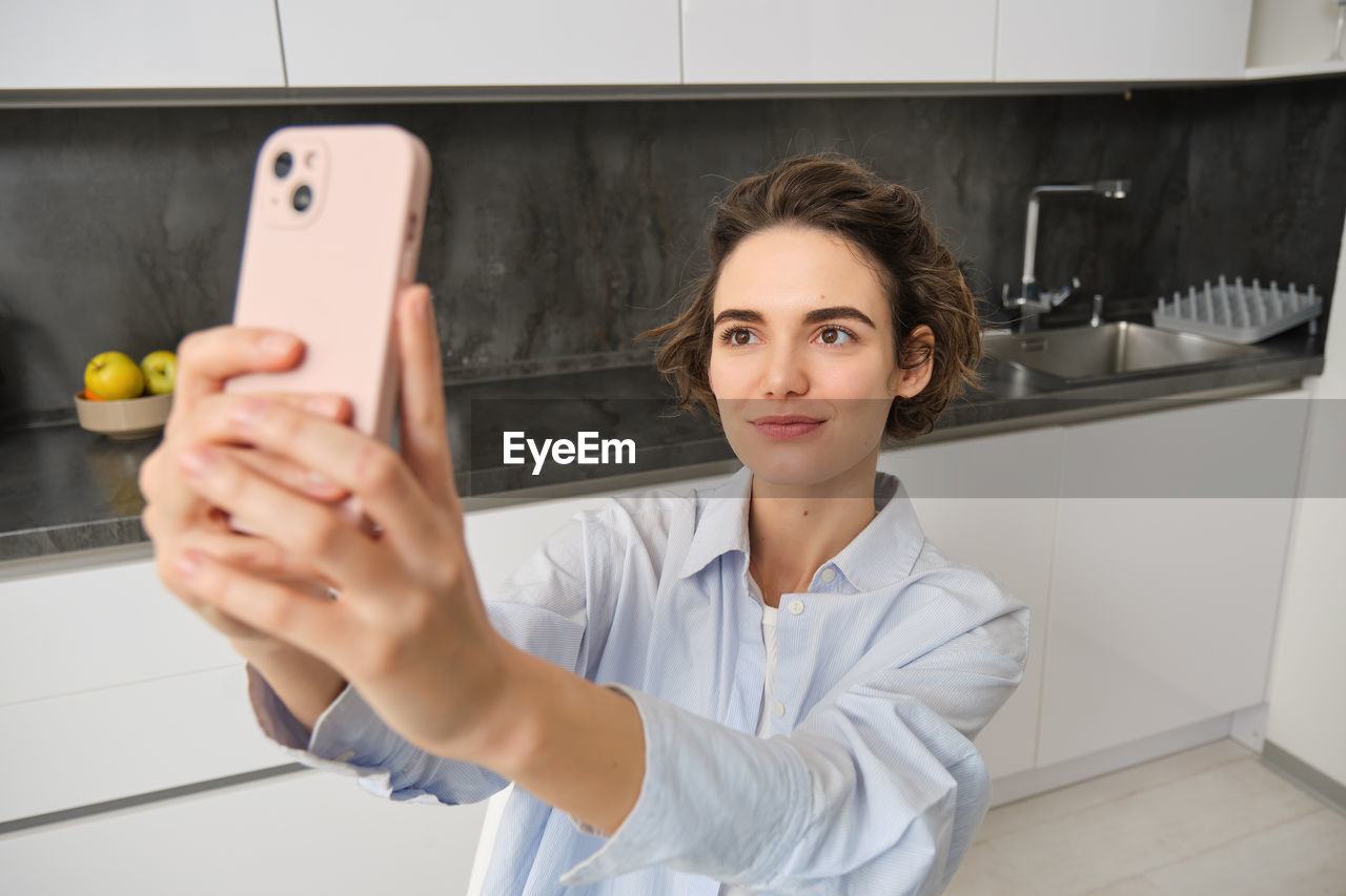 portrait of smiling young woman using mobile phone