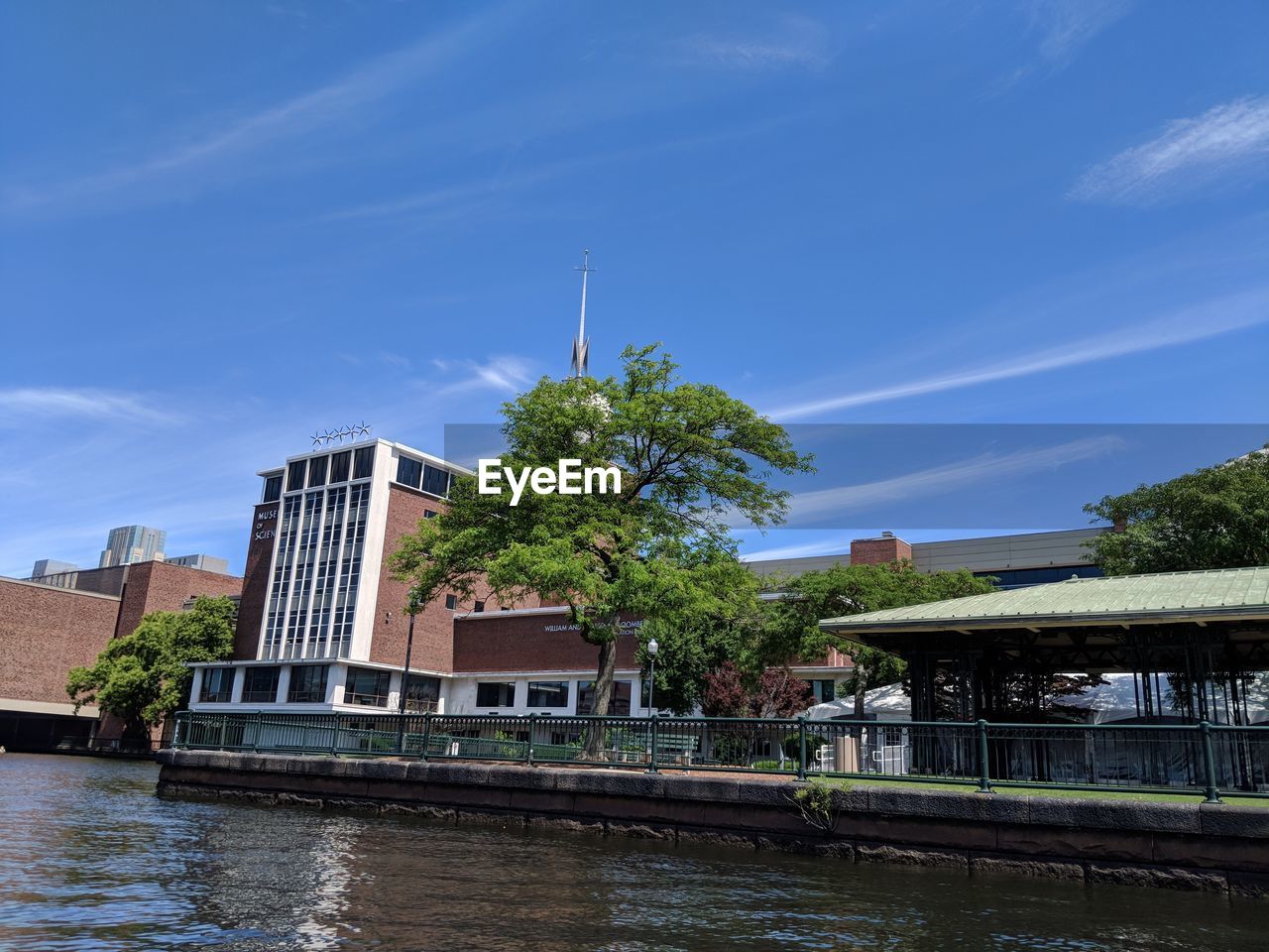 BUILDINGS BY RIVER AGAINST SKY