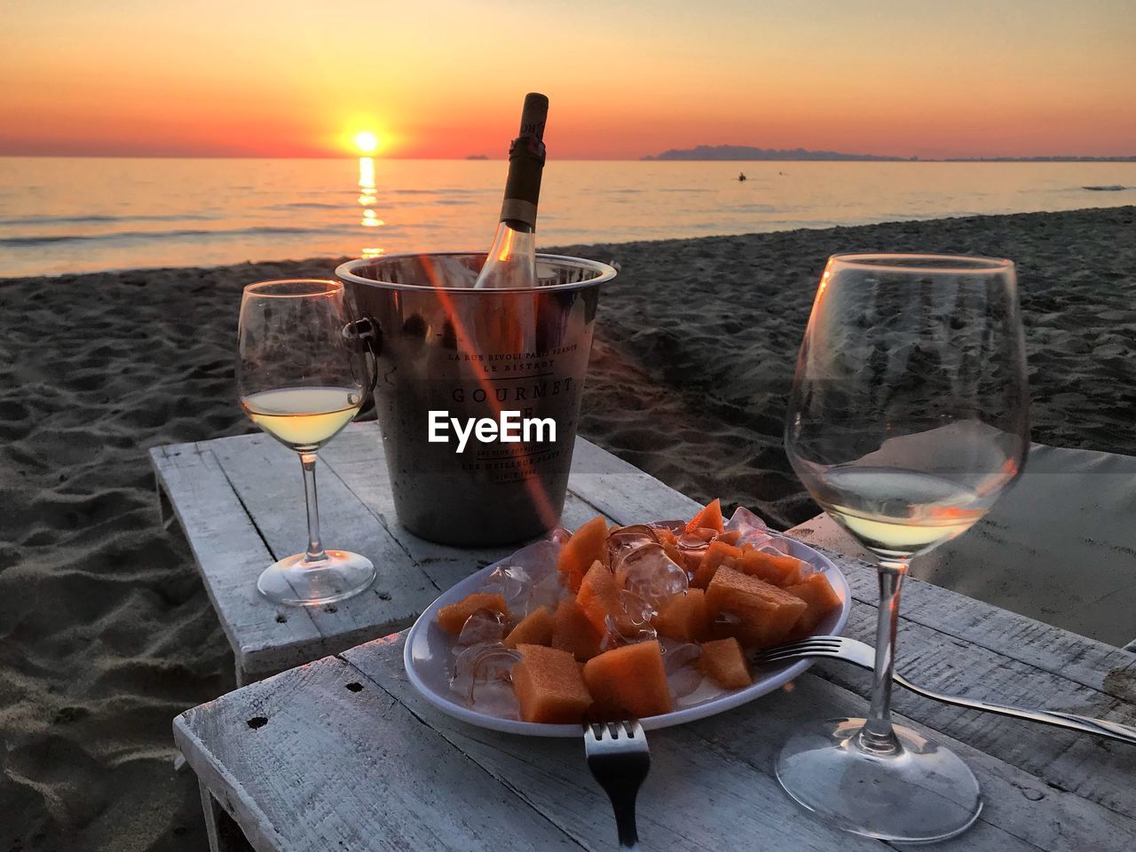 FOOD ON TABLE AT BEACH DURING SUNSET